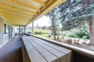 a porch with a wooden bench and a large window at Hi Country Haus 11-2 in Winter Park