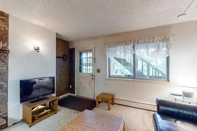 a living room with a couch and a tv and a window at Hi Country Haus 11-2 in Winter Park