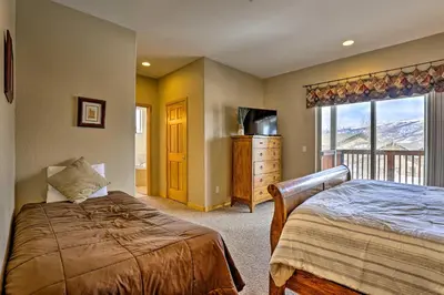 a bedroom with a bed and a television and a window at 11 Mi to Keystone Silverthorne Condo with Deck in Silverthorne
