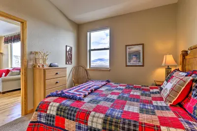 a bedroom with a bed with a checkered blanket at 11 Mi to Keystone Silverthorne Condo with Deck in Silverthorne
