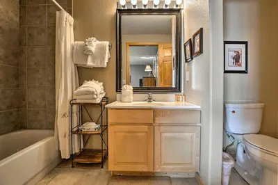 a bathroom with a sink and a tub and a mirror at 11 Mi to Keystone Silverthorne Condo with Deck in Silverthorne