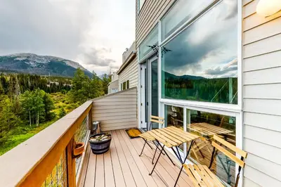 a balcony with a table and chairs and mountains at Watch Hill Lofted in Silverthorne
