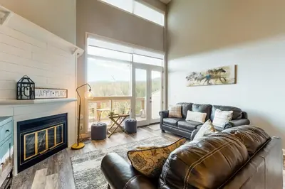 a living room with a leather couch and a fireplace at Watch Hill Lofted in Silverthorne