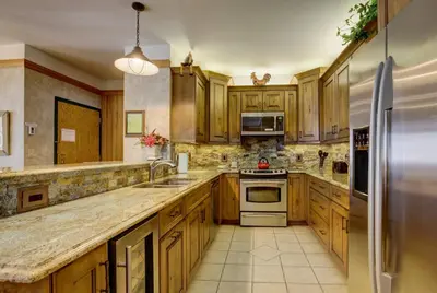 a kitchen with wooden cabinets and stainless steel appliances at Chateaux DuMont 2716 in Keystone