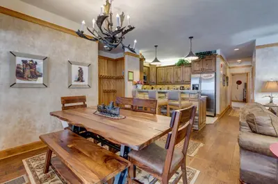 a dining room and kitchen with a wooden table and chairs at Chateaux DuMont 2716 in Keystone