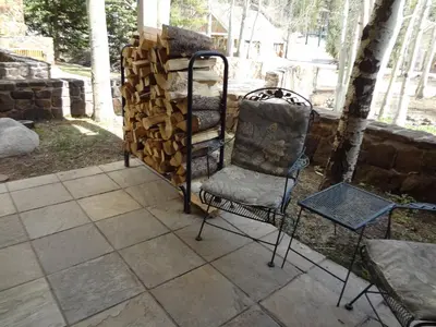 a chair sitting next to a pile of fire wood at Chateaux DuMont 2716 in Keystone