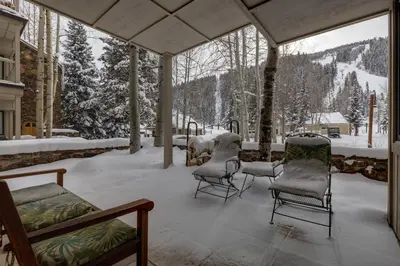 a covered porch with chairs and snow on the ground at Chateaux DuMont 2716 in Keystone