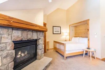 a bedroom with a fireplace and a bed in it at Buffalo Lodge by Summit County Mountain Retreats in Keystone