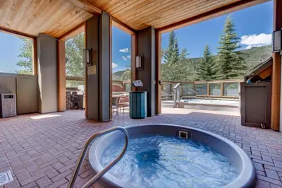 a large tub in a room with a patio at Buffalo Lodge by Summit County Mountain Retreats in Keystone