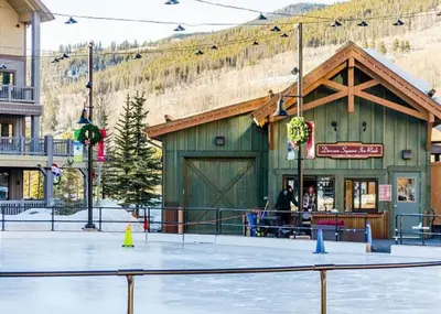 a green building with a mountain in the background at Buffalo Lodge by Summit County Mountain Retreats in Keystone