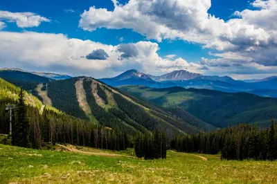 a view of the mountains from a grassy hill at Arapahoe Lodge by Summit County Mountain Retreats in Keystone