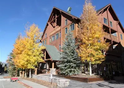 a large wooden building with trees in front of it at Arapahoe Lodge by Summit County Mountain Retreats in Keystone