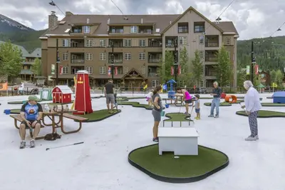 a group of people playing golf in front of a building at Dakota Lodge by Summit County Mountain Retreats in Keystone