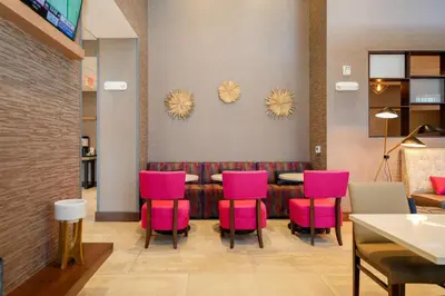 a restaurant with pink chairs and a table at Hampton Inn & Suites Aurora South, Co in Aurora