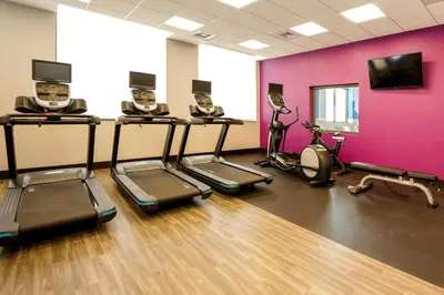 a gym with cardio machines and a pink wall at Hampton Inn & Suites Aurora South, Co in Aurora