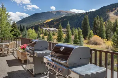 two bbq grilling equipment on a deck with a mountain at Hidden River Lodge by Summit County Mountain Retreats in Keystone