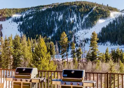 two bbqs on a deck with a view of a mountain at Hidden River Lodge by Summit County Mountain Retreats in Keystone