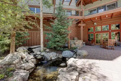 a house with a pond in front of it at Jackpine Lodge by Summit County Mountain Retreats in Keystone