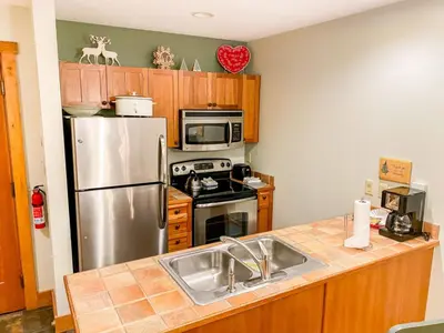 a kitchen with a sink and a stainless steel refrigerator at Red Hawk Lodge by Summit County Mountain Retreats in Keystone
