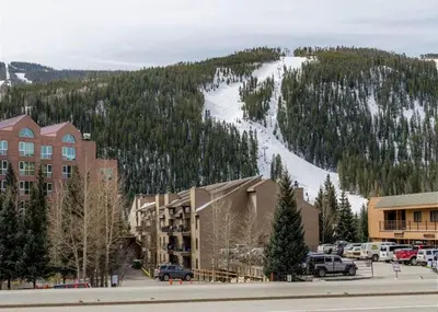 a resort with a snow covered mountain in the background at Red Hawk Lodge by Summit County Mountain Retreats in Keystone