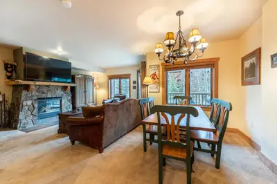 a living room with a table and a couch and a fireplace at Red Hawk Lodge by Summit County Mountain Retreats in Keystone