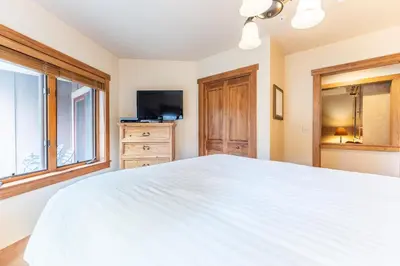 a bedroom with a large white bed and a window at Red Hawk Lodge by Summit County Mountain Retreats in Keystone