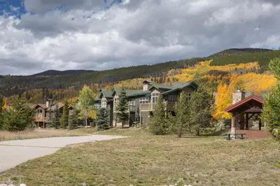 a large house with a mountain in the background at Snake River Village by Summit County Mountain Retreats in Keystone