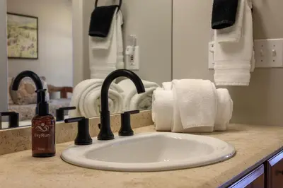 a bathroom sink with a bottle of soap and towels at Trademark Condo Short Walk to Shuttle in Winter Park