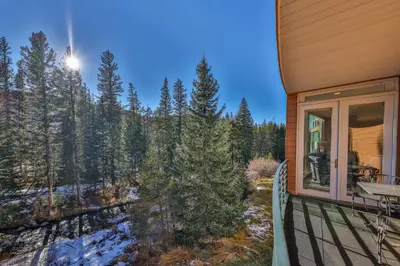 a porch of a house with a view of the woods at Trademark Condo Short Walk to Shuttle in Winter Park