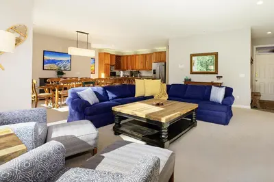 a living room with blue couches and a table at Trademark Condo Short Walk to Shuttle in Winter Park