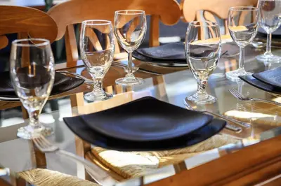 a table with black plates and wine glasses on it at Trademark Condo Short Walk to Shuttle in Winter Park