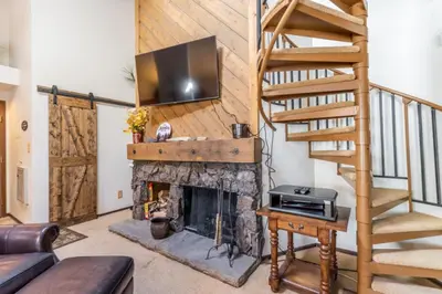 a living room with a fireplace with a television above it at Flying Dutchman by Summit County Mountain Retreats in Keystone