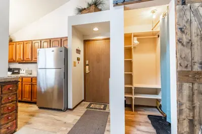 a kitchen with a refrigerator and wooden cabinets at Flying Dutchman by Summit County Mountain Retreats in Keystone
