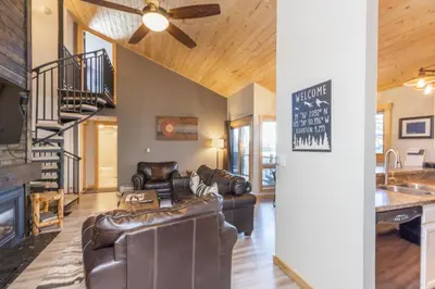 a living room with leather furniture and a staircase at Flying Dutchman by Summit County Mountain Retreats in Keystone