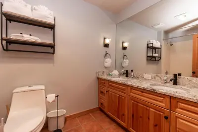 a bathroom with two sinks and a toilet and a mirror at Expedition Station by Summit County Mountain Retreats in Keystone