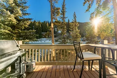 a chair on a deck with a stove and a grill at Ironwood Townhome 2989 - Keystone2989com in Keystone