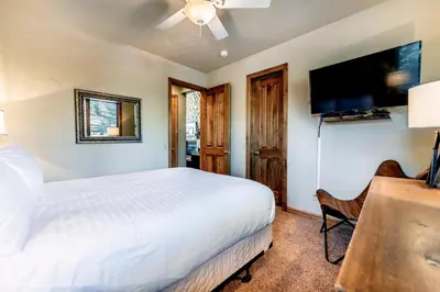 a bedroom with a bed and a flat screen tv at Ironwood Townhome 2989 - Keystone2989com in Keystone
