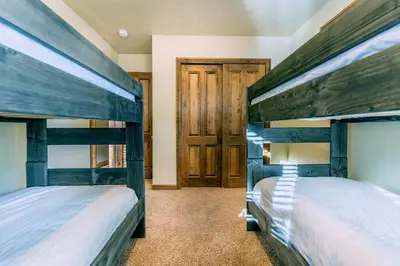 two bunk beds in a room with wooden doors at Ironwood Townhome 2989 - Keystone2989com in Keystone
