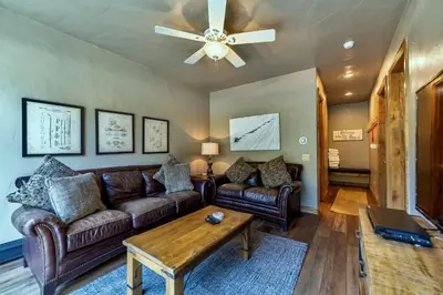 a living room with leather couches and a ceiling fan at Ironwood Townhome 2989 - Keystone2989com in Keystone
