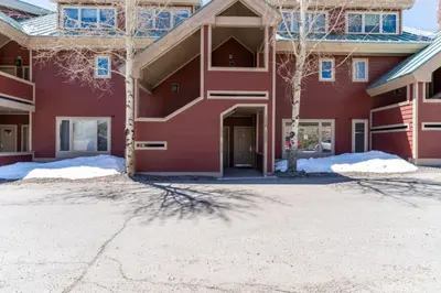 a red building with snow in front of it at Lakeshore by Summit County Mountain Retreats in Keystone