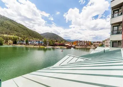 a view of a body of water next to a building at Lakeshore by Summit County Mountain Retreats in Keystone