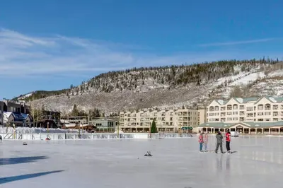 a group of people standing on the ice in front of a hotel at Lakeshore by Summit County Mountain Retreats in Keystone