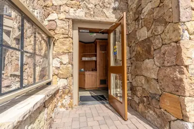 an open door into a stone building with a stone wall at Lone Eagle by Summit County Mountain Retreats in Keystone
