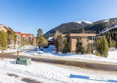 a building on the side of a road in the snow at River Run Townhomes by Summit County Mountain Retreats in Keystone