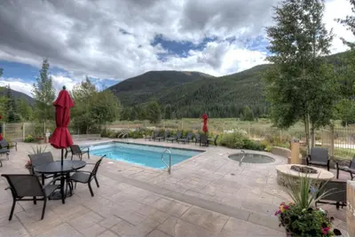 a patio with a pool and a table and chairs at Red Hawk Townhomes by Summit County Mountain Retreats in Keystone