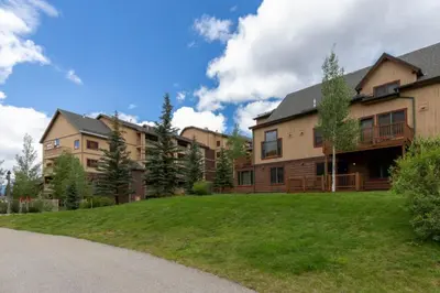 a large apartment building with a green yard at Red Hawk Townhomes by Summit County Mountain Retreats in Keystone