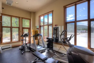 a gym with treadmills and elliptical machines and windows at Red Hawk Townhomes by Summit County Mountain Retreats in Keystone
