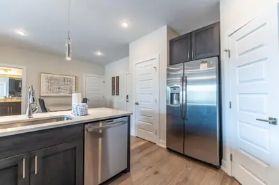 a kitchen with a stainless steel refrigerator and wooden floors at Sail Lofts by Summit County Mountain Retreats in Dillon