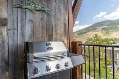 a grill on a balcony with a view of a hill at Sail Lofts by Summit County Mountain Retreats in Dillon