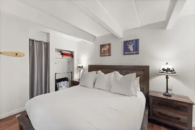 a bedroom with a large white bed and a lamp at The Lodge at Lake Dillon 111 in Dillon
